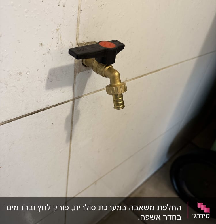ברז מתכת עם ידית שחורה על קיר אריחים